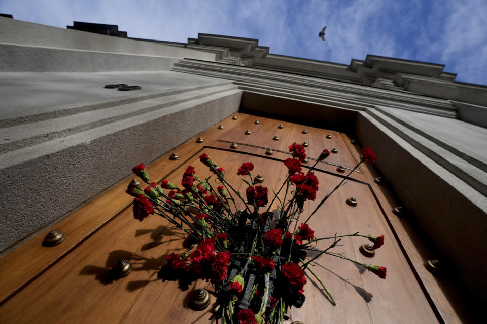 Flowers adorn the door of the east entrance of La Moneda presidential palace on the 50th anniversary of the military coup that toppled the government of late President Salvador Allende in Santiago, Chile, Monday, Sept. 11, 2023. Allende's body was carried by soldiers and firefighters through this side entrance after the coup. (AP Photo/Esteban Felix)