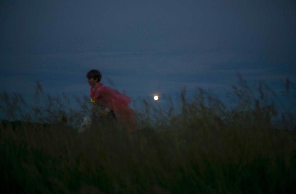 Children play as a 'strawberry’ moon rises on the longest day of the year at Stonehenge on Salisbury Plain in southern England, Britain June 20, 2016. REUTERS/Kieran Doherty