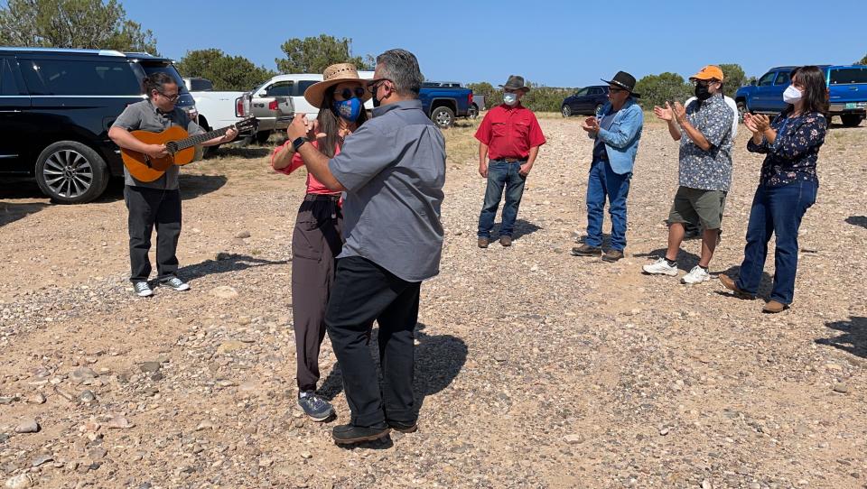 This Aug. 31, 2021 photo shows U.S. Rep. Teresa Leger Fernández dancing with state Sen. Leo Jaramillo near Abiquiu, New Mexico, as David García, left, plays a corrido, or folk song, about the traditional irrigation systems known as acequias. The systems are facing more pressure amid drought and warmer temperatures. (AP Photo/Susan Montoya Bryan)