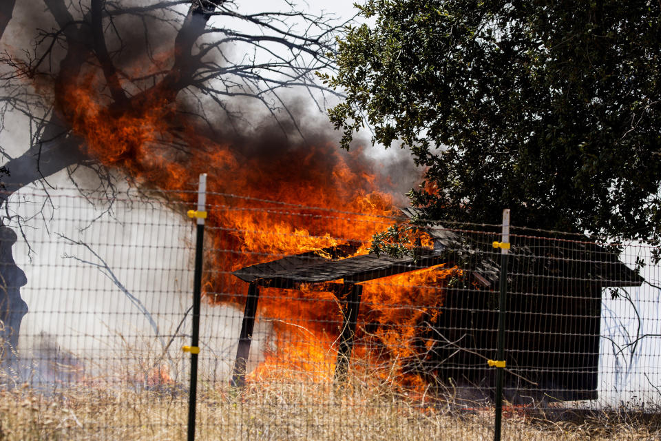 The Apple Fire burns a structure in Cherry Valley, Calif., Saturday, Aug. 1, 2020. A wildfire northwest of Palm Springs flared up Saturday afternoon, prompting authorities to issue new evacuation orders as firefighters fought the blaze in triple-degree heat.(AP Photo/Ringo H.W. Chiu)