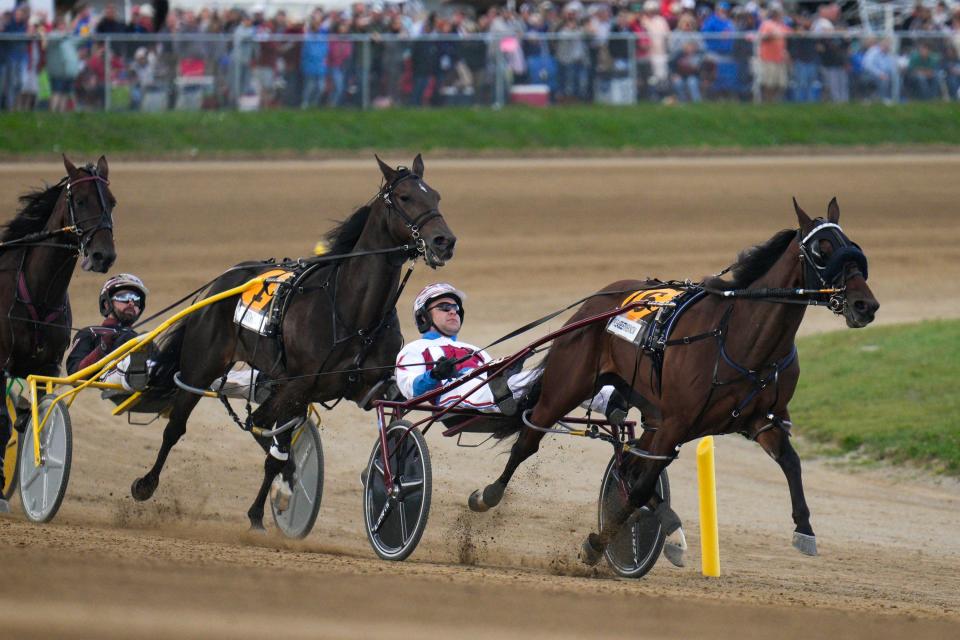 Plainridge Park Casino offers harness racing April through November, similar to the style depicted in the photo of the Little Brown Jug harness race held at Delaware County Fairgrounds, in Ohio, in September.