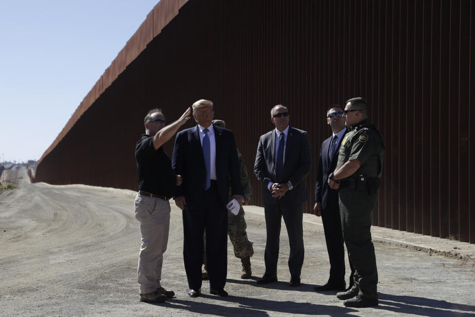 President Donald Trump tours a section of the southern border wall, Wednesday, Sept. 18, 2019, in Otay Mesa, Calif., with acting commissioner of Customs and Border Protection Mark Morgan, third from right, and acting Homeland Secretary Kevin McAleenan, second from right. (AP Photo/Evan Vucci)