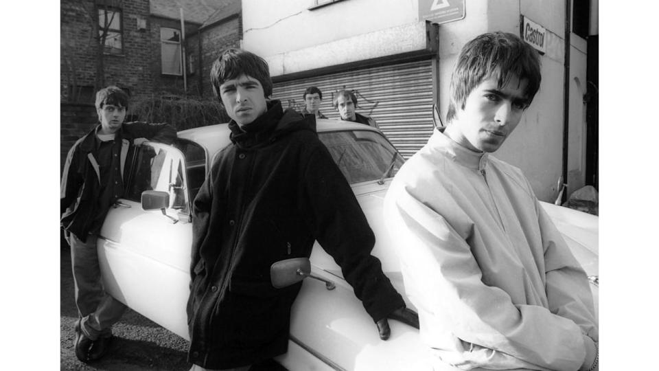 Group portrait of British rock band Oasis leaning against a Jaguar XJ6 car in Withington, Manchester, United Kingdom, 30th November 1993. 