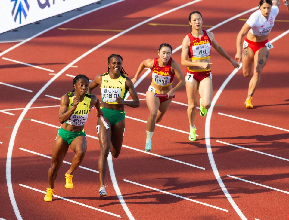 Jamaica's Kemba Nelson, left, takes the baton from teammate Remona Buechell on their way to advance out of heat one of the women's 4x100 meter relay during day eight of the World Athletics Championships at Hayward Field in Eugene, Oregon Friday July 22, 2022. 