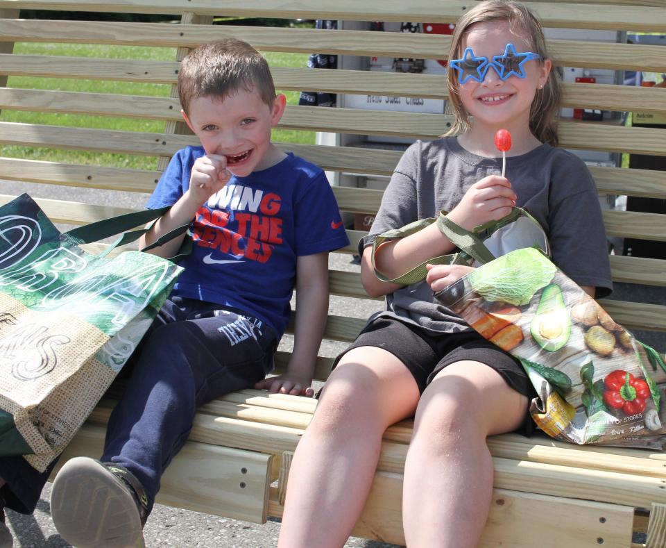 Matthew and Raelan enjoy strawberry lollipops at the Strawberry Festival in Portland, Tenn., on Saturday, May 14, 2022.