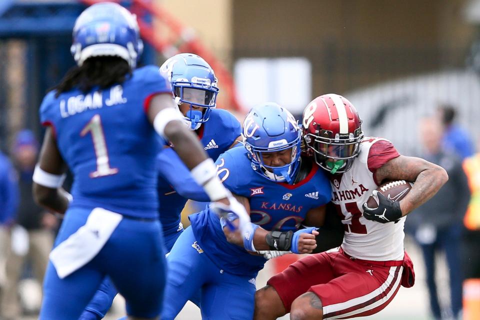 Kansas linebacker Rich Miller (30) tackles Oklahoma wide receiver Jadon Haselwood (11) during a game on Oct. 23, 2021, in Lawrence.