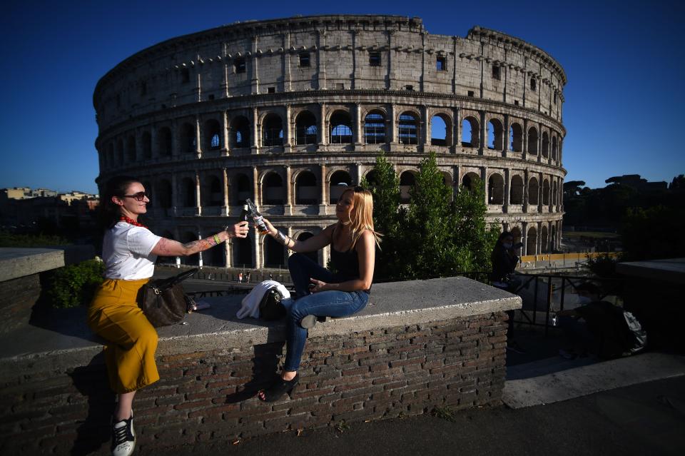 Young women share an aperitif drink by the Colosseum in Rome on May 21, 2020, after the country eases its two-month lockdown. (Photo: FILIPPO MONTEFORTE via Getty Images)