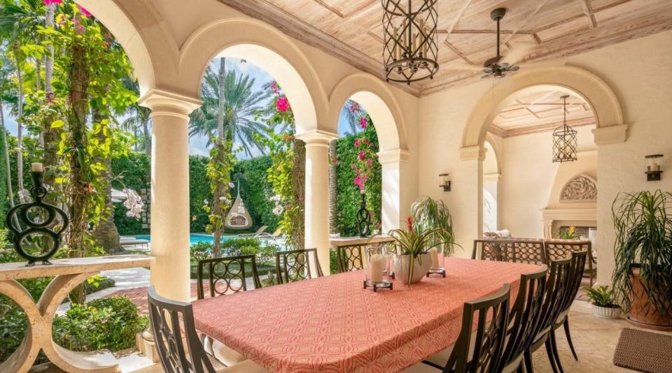 With a cypress ceiling and outdoor fireplace, a colonnaded loggia  looks out to the pool at a house at 240 Clarke Ave. in Palm Beach. The property just changed hands for $32.375 million.