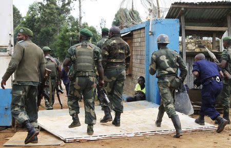 Congolese army and police officers charge to disperse demonstrators outside the United Nations Organization Mission in the Democratic Republic of the Congo (MONUC) base in Mavivi near Beni in North Kivu province October 22, 2014. REUTERS/Kenny Katombe