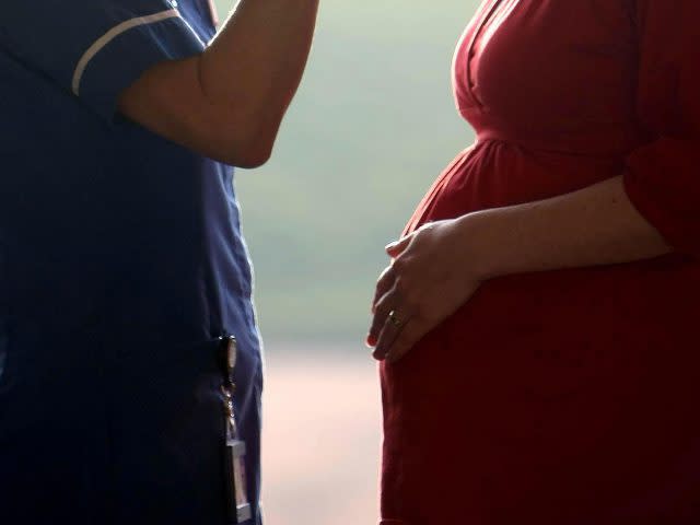 A midwife talking to a pregnant woman (David Jones/PA)