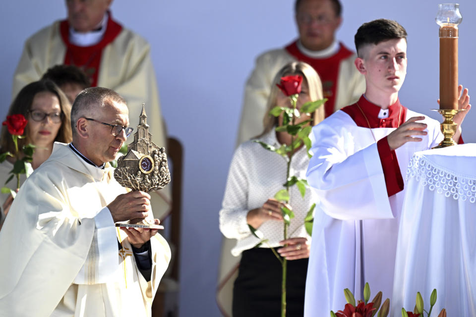 A priest bringing to the altar relics of the Polish Ulma family during beatification Mass in which the Vatican beatified the family, including small children, who were killed by the Nazis in 1944 for having sheltered Jews, in the Ulmas' home village of Markowa, Poland, on Sunday, Sept.10, 2023. The Vatican beatified also the Ulmas' unborn child, saying it was born during the killings and was baptized in the martyred mother's blood. (AP Photo)