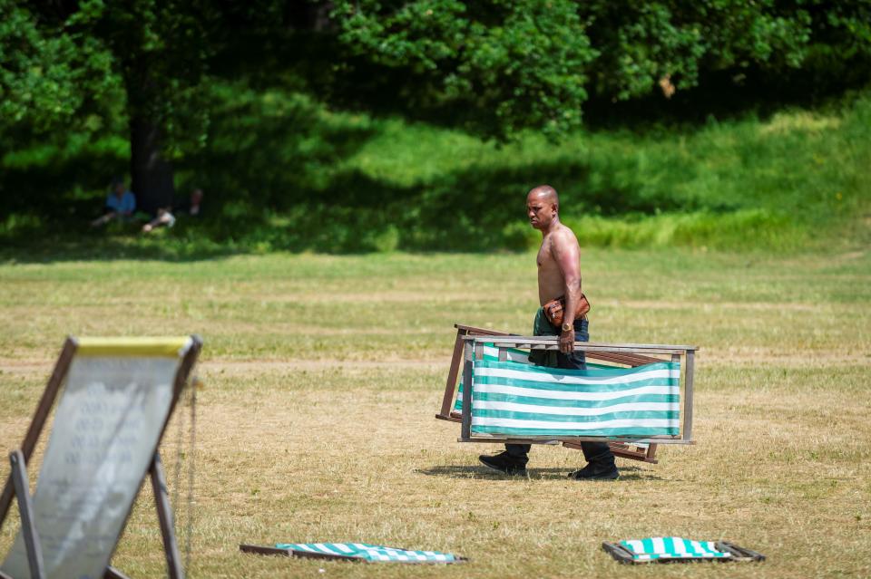 A man carries deckchairs at Hyde Park in London, Britain, on June 15, 2023. Parts of Britain are in the grip of a heatwave currently. (Photo by Stephen Chung/Xinhua via Getty Images)