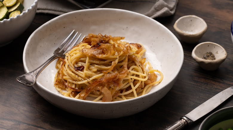 caramelized onion pasta in bowl with fork