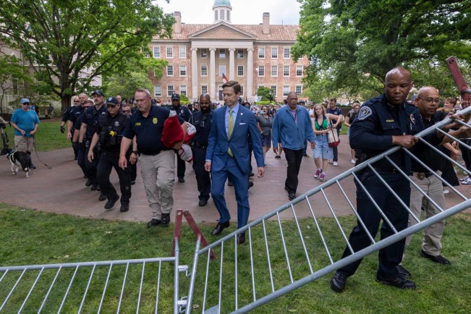 Interim Chancellor Lee Roberts and police prepare to rehang an American flag after it was brought down by demonstrators and replaced with a Palestinian flag Tuesday, April 30, 2024 at UNC-Chapel Hill. About 1000 pro-Palestinian demonstrators rallied after a “Gaza solidarity encampment” was removed by police early Tuesday morning.