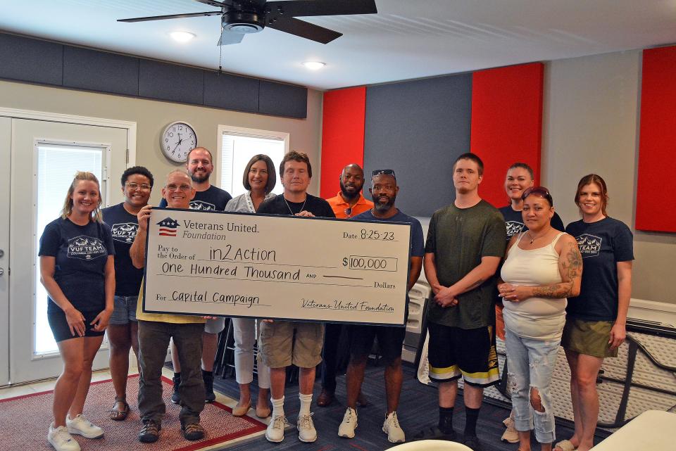 Members of the Veterans United Foundation presented a $100,000 check Friday to In2Action staff and board members and In2Action program participants in support of the transitional housing and substance use recovery program's capital campaign.