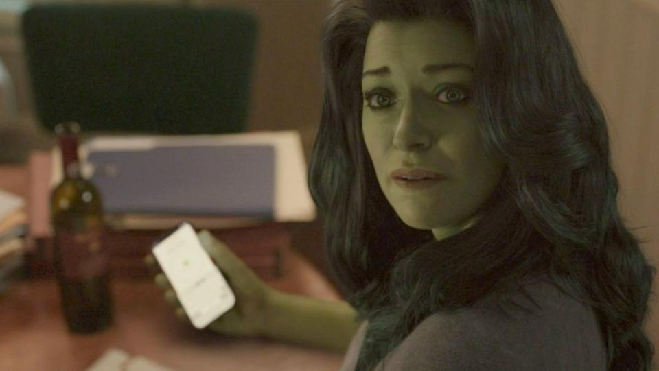 she hulk looking into camera while holding cell phone 