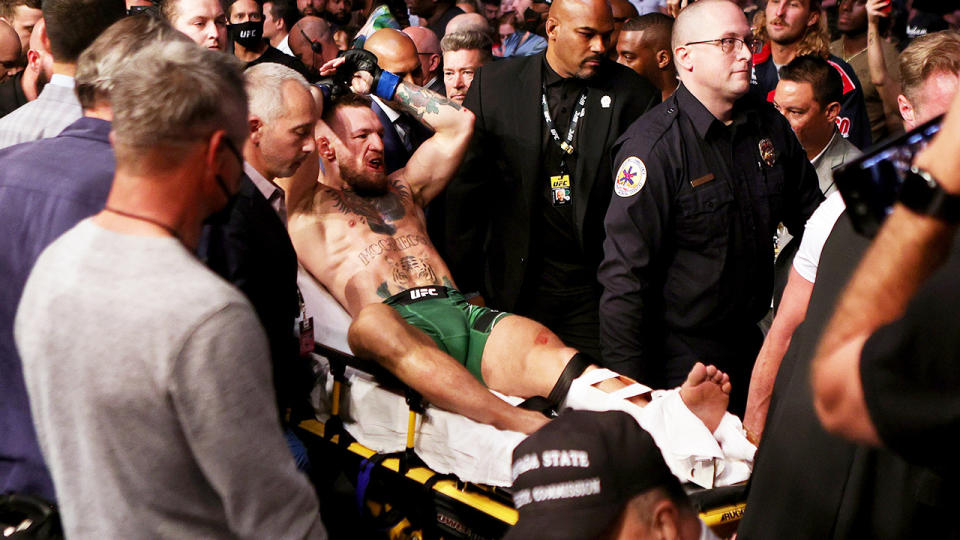 Conor McGregor, pictured here being carried out of the arena on a stretcher at UFC 264.