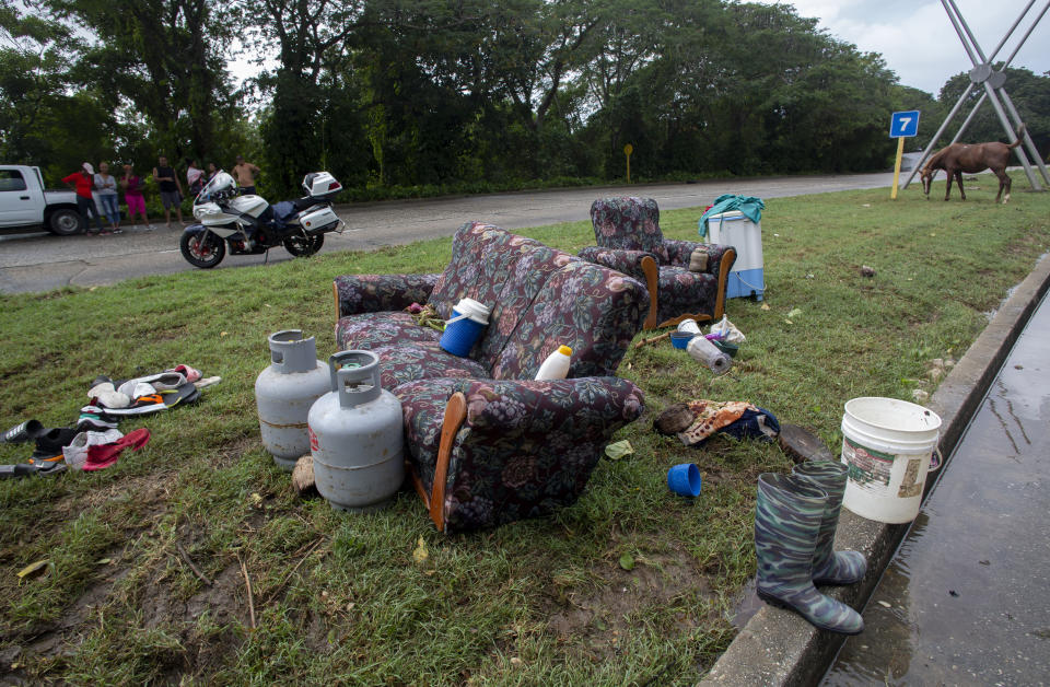 Muebles y otras pertenencias rescatadas de una casa inundada por lluvias torrenciales, puestas a secar al lado de una carretera en La Habana, Cuba, el miércoles 13 diciembre de 2023. (AP Foto/Ismael Francisco)