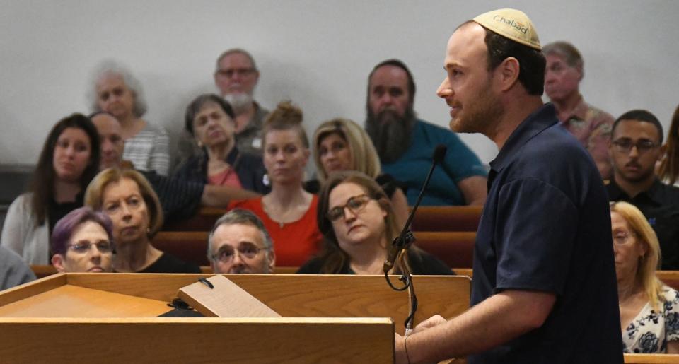 Omri Einav, a Cocoa resident and reservist in the Israeli Defense Force, talks during an interfaith prayer gathering at Temple Beth Sholom. Einav talked about gathering donations for Israeli soldiers, including funds to buy supplies and water.