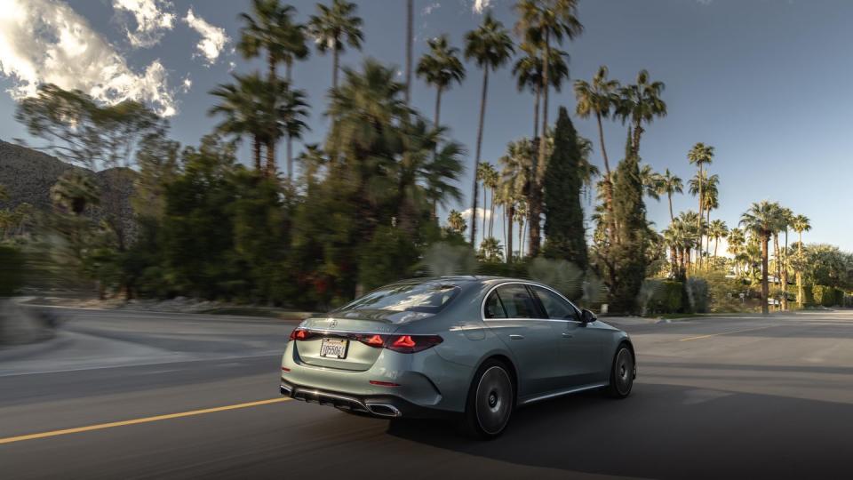 2024 mercedes benz e 350 driving on a road past palm trees