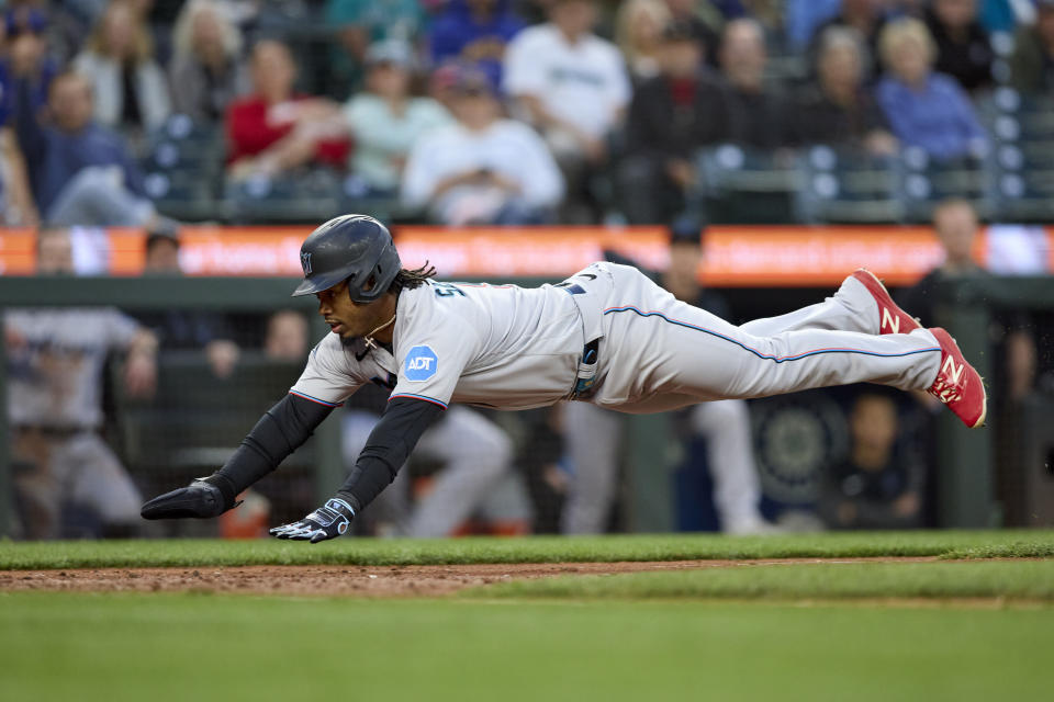 Miami Marlins' Jean Segura dives home to score on a sacrifice fly hit by Jonathan Davis against the Seattle Mariners during the eighth inning of a baseball game Wednesday, June 14, 2023, in Seattle. (AP Photo/John Froschauer)