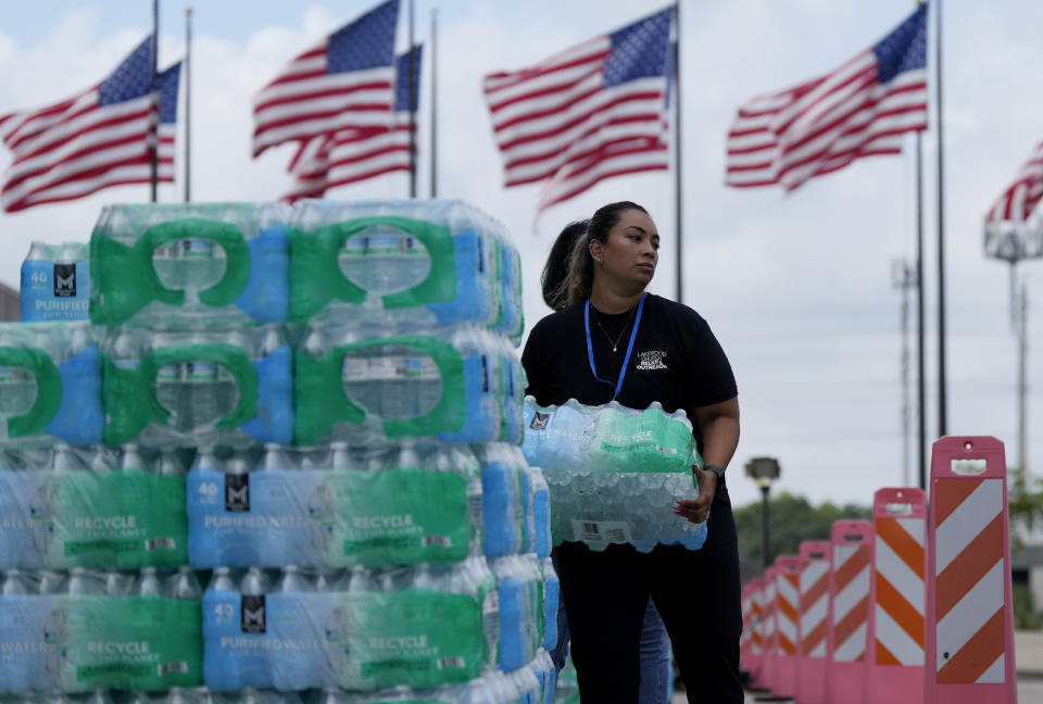 FILE - Staff at Lakewood Church hand out water and operate a cooling station, Tuesday, July 9, 2024, in Houston. As the city slowly struggles to recover after Hurricane Beryl left millions without power on Monday, July 8, experts say it's time to rethink how cities are preparing for and responding to weather disasters. (AP Photo/Eric Gay, File)