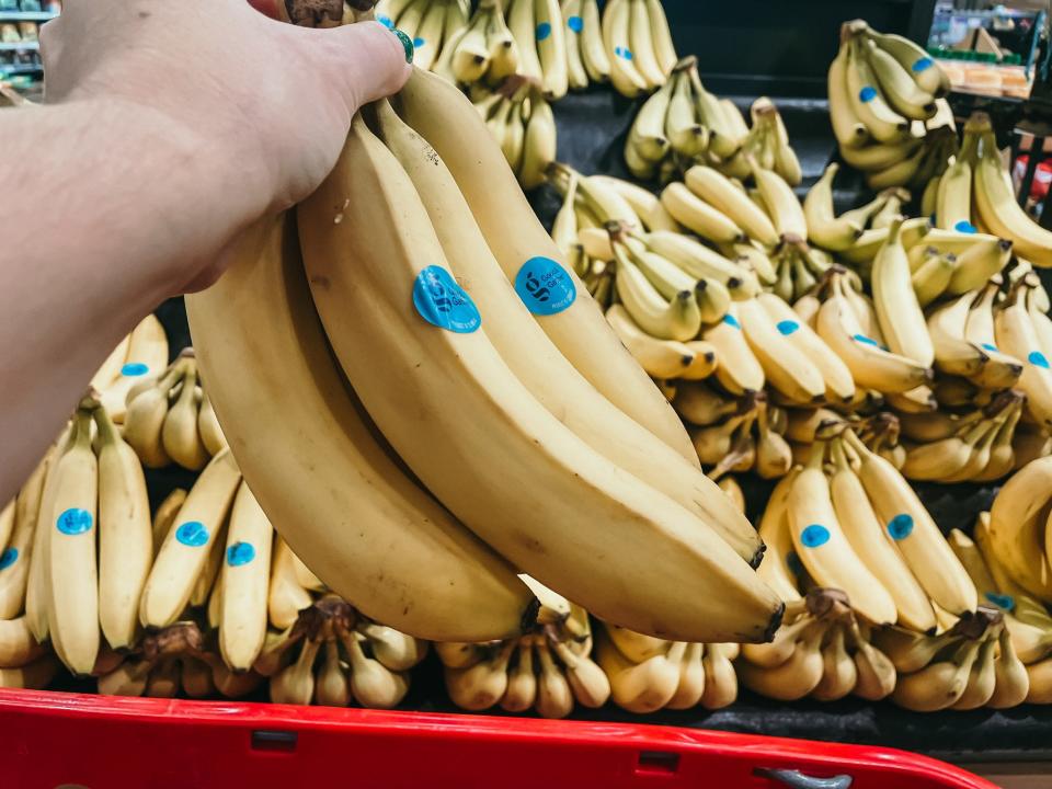 hand holding up a bunch of bananas at target