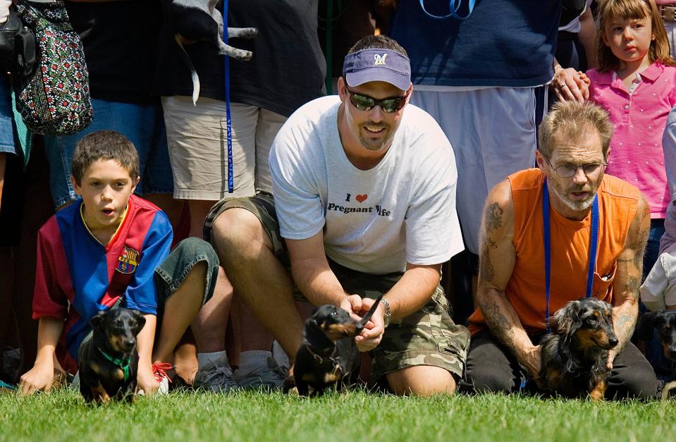 Bryce Schilz, 11, from New Berlin (far left), shouts encouragement to Sally, the family's 1-year-old dachshund, as she runs toward the finish line during German Fest in 2007.