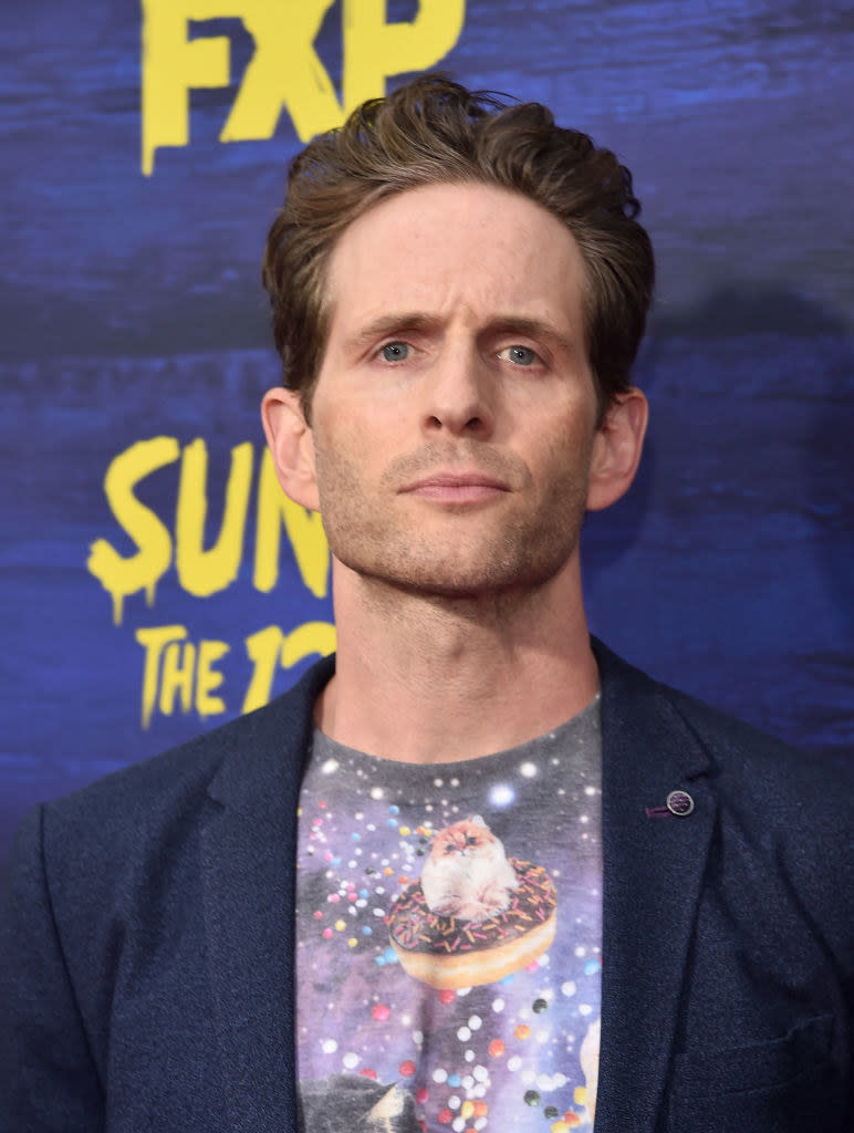 Howerton at an event wearing an astral cat shirt and blazer