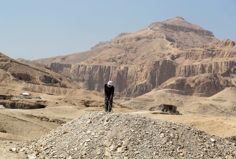 A worker is digging at the site where nearly 30 painted coffins were discovered, at Al-Asasif Necropolis in the Vally of Kings in Luxor