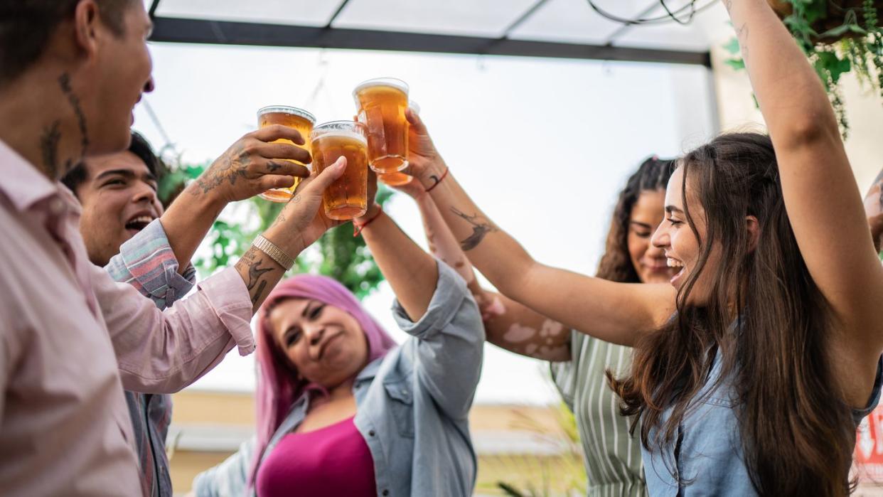 friends drinking beer and doing a celebratory toast at a bar