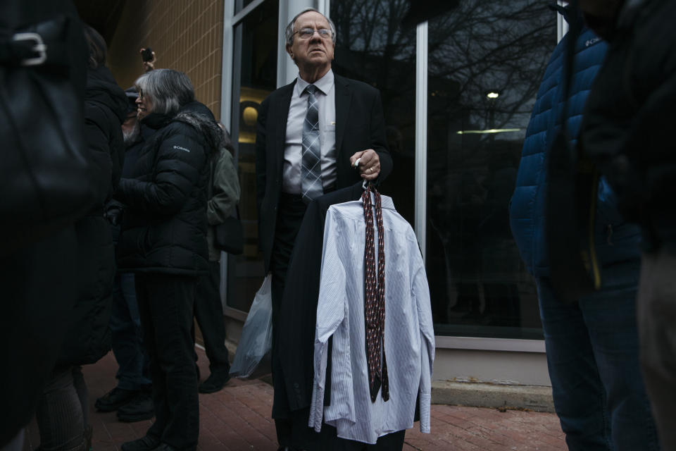 Gary Benjamin looks on as he holds the extra clothes he and his wife, Melody Hart, brought Ansly Damus, after a continuance was issued in his asylum case.&nbsp;