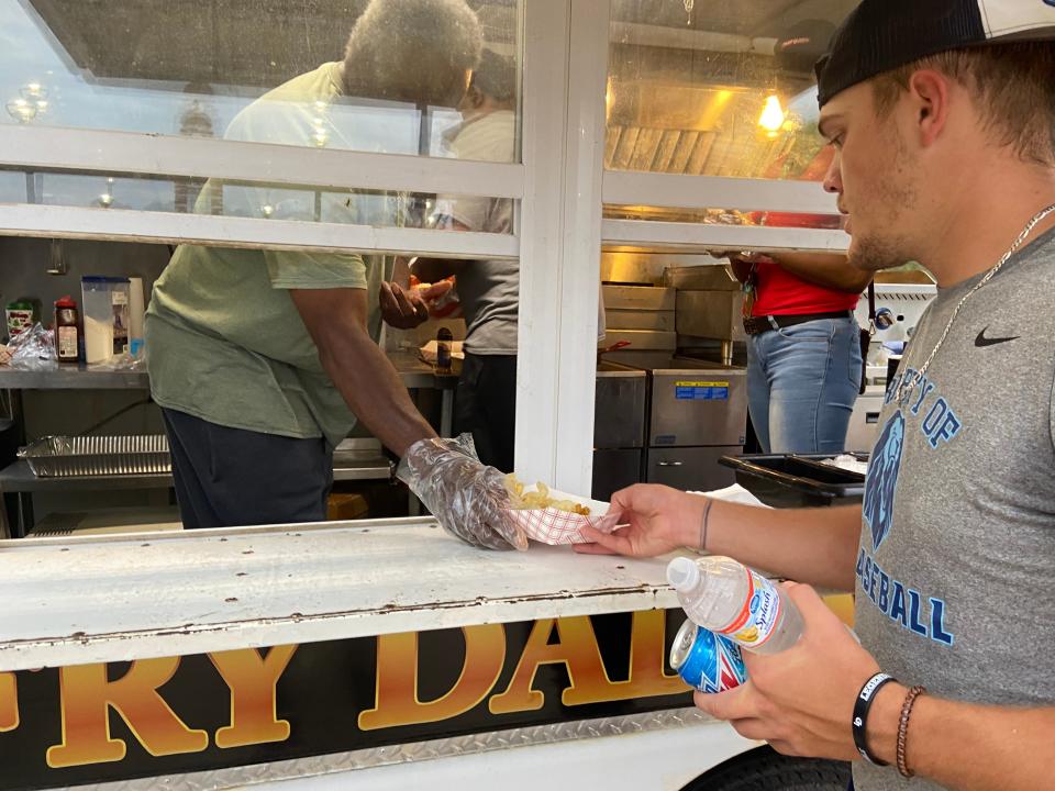 Lucas Petross, sophomore and baseball team pitcher, grabs some fried chicken from Fry Daddy's food truck.