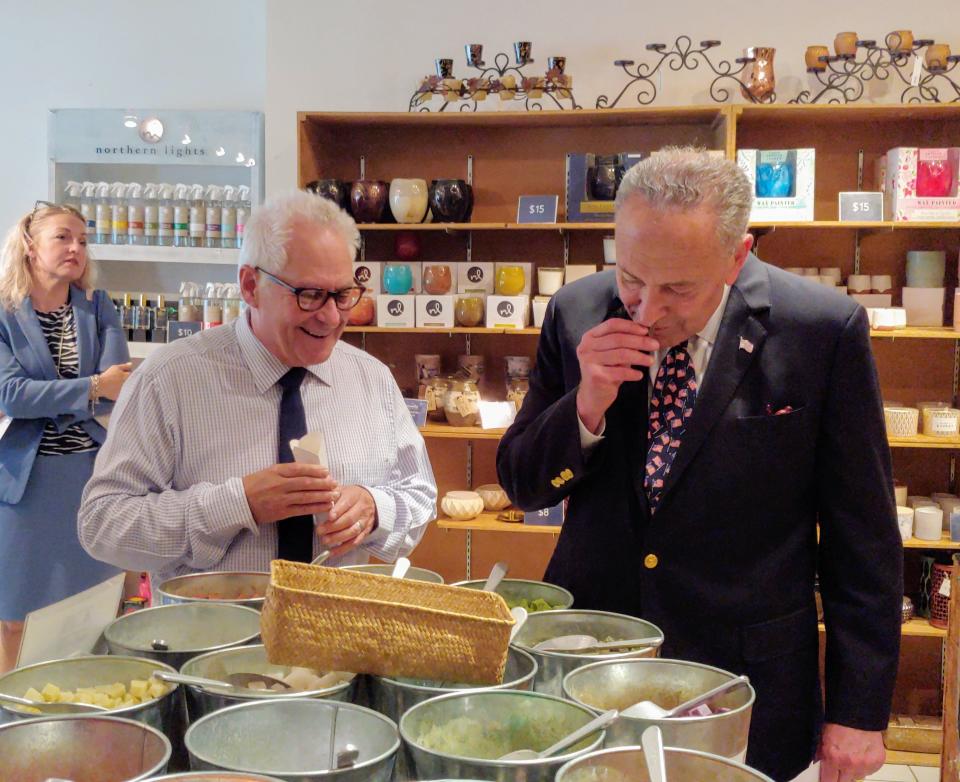 Senate Majority Leader Chuck Schumer, right, samples some of the products in the Northern Lights Candles showroom during a visit to the Wellsville manufacturer in 2019. At left is founder Andy Glanzman.
