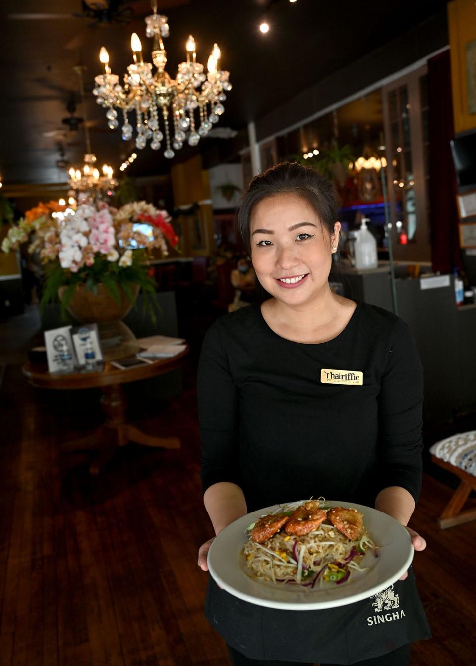 Waitress Yok Leksrisakul with a dish of pad Thai over colossal shrimp   at Thairiffic, a Thai restaurant in downtown Marlborough, May 27, 2022.  