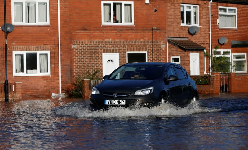 A car drives through a flooded street in Bentley, north of Doncaster