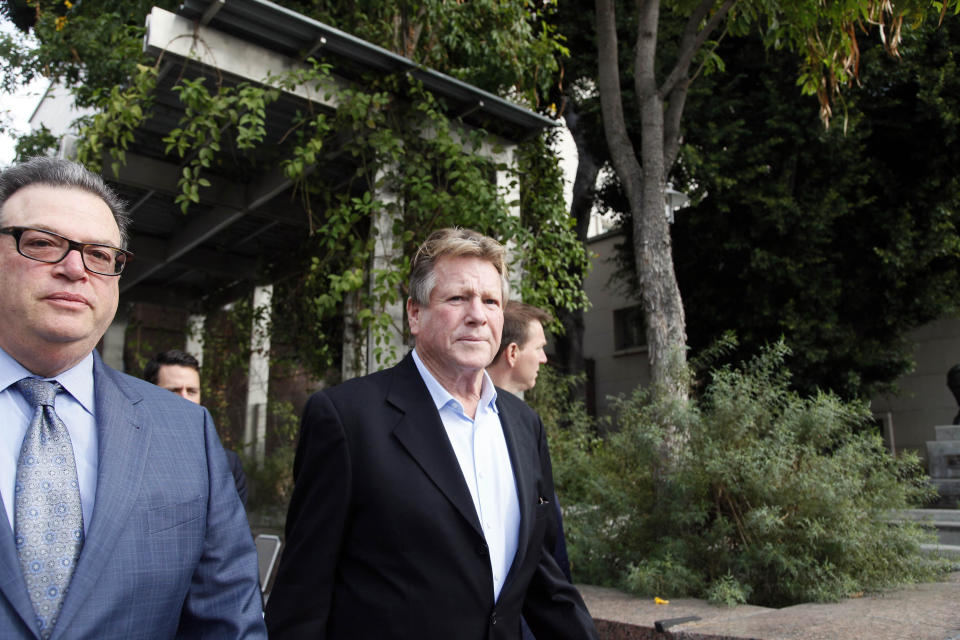 In this Monday, Dec. 2, 2013 file photo, actor Ryan O’Neal, right, leaves court after he testified in a Los Angeles courtroom about his relationship with Farrah Fawcett and his claimed ownership of an Andy Warhol portrait of the actress. O’Neal told a jury on Wednesday, Dec. 11, 2013, that he feels a close connection to the Warhol portrait of Fawcett that hangs in his home and reiterated that it was a gift from the late artist. (AP Photo/Nick Ut, File)