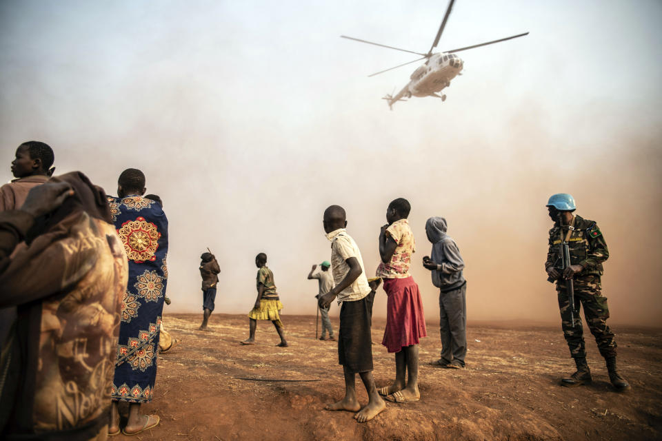 Displaced people watch the United Nations helicopter carrying Under-Secretary-General for Peace Operations Jean Pierre Lacroix land in Bunia, eastern Congo, Tuesday Feb. 22, 2022. Elections, coups, disease outbreaks and extreme weather are some of the main events that occurred across Africa in 2022. Experts say the climate crisis is hitting Africa “first and hardest.” Kevin Mugenya, a senior food security advisor for Mercy Corps said the continent of 54 countries and 1.3 billion people is facing “a catastrophic global food crisis” that “will worsen if actors do not act quickly.” (AP Photo/Moses Sawasawa)