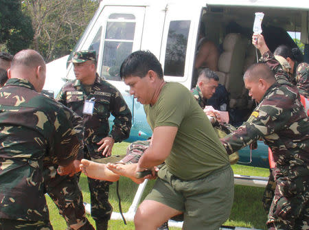 Soldiers unload from a presidential helicopter a wounded member of Philippine President Rodrigo Duterte's presidential security group who was airlifted at an army camp in Cagayan de Oro after being hit in a roadside bomb attack in Lanao del Sur, Philippines November 29, 2016. Armed Forces of the Philippines/Handout via REUTERS