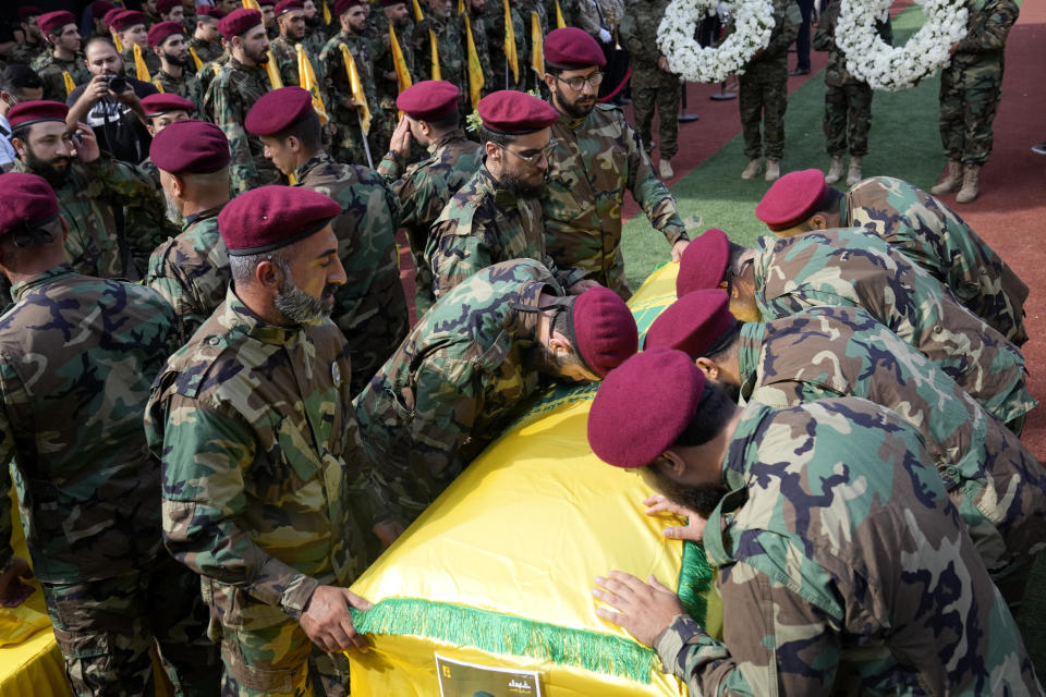 Hezbollah members mourn over the coffins of two of their comrades who were killed on Wednesday when a handheld device exploded, during a funeral procession in the southern suburbs of Beirut, Thursday, Sept. 19, 2024. (AP Photo/Hussein Malla)