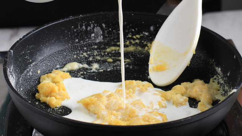 pouring milk into pan with roux