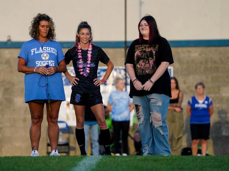 Franklin Central's Breece Bass (9) is escorted to midfield by her mom, Brandi (left) and sister Breanne, on senior night, before a game between Franklin Central High School and Ben Davis High School at FCHS on Monday, Aug. 28, 2023, in Indianapolis.