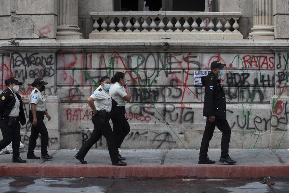 Agentes de la policía patrullan el domingo 22 de noviembre de 2020 frente al edificio del Congreso que resultó dañado durante unas protestas en la Ciudad de Guatemala. (Foto AP/Moisés Castillo)