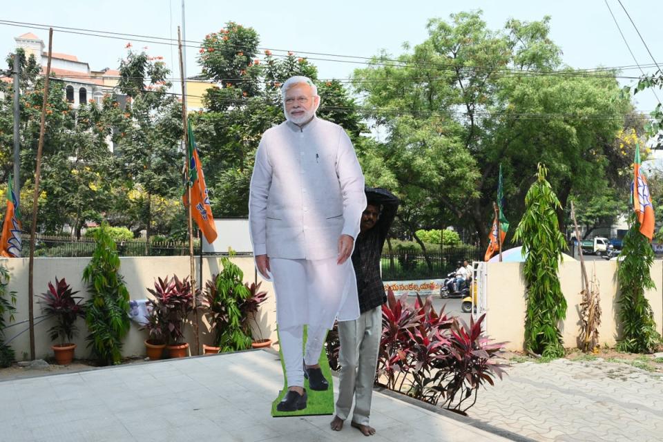 A worker carries a cutout of India's Prime Minister Narendra Modi outside a Bharatiya Janata Party (BJP) office (AFP via Getty Images)