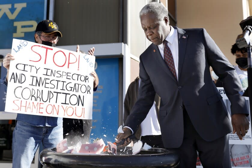 VAN NUYS-CA-JANUARY 21, 2022: Mayoral candidate Mel Wilson takes a hammer to a piggy bank during a rally outside DWP in Van Nuys surrounded by supporters on Friday, January 21, 2022. (Christina House / Los Angeles Times)