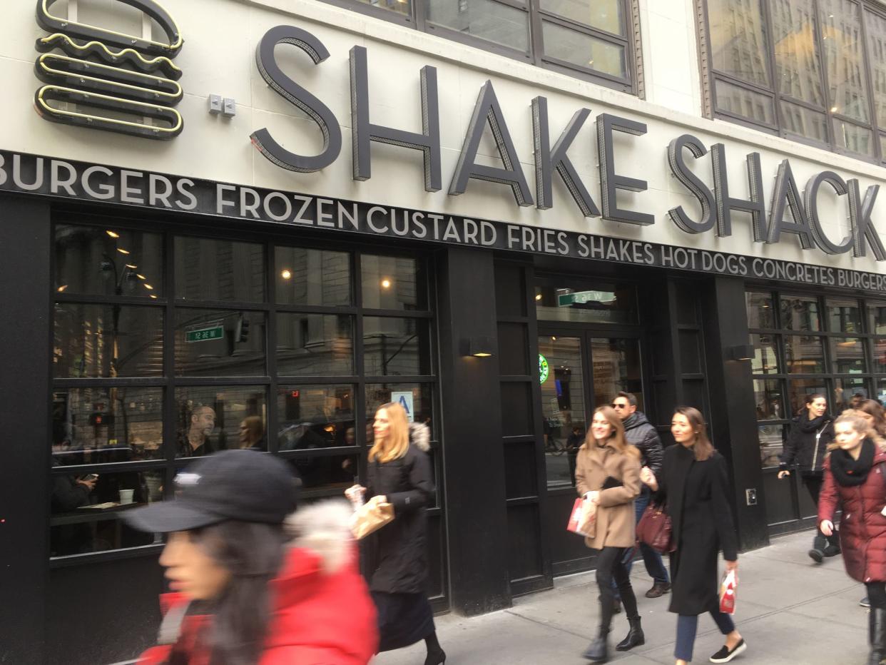 1 February 2017 - New York City: People passing a Shake Shack in Midtown Manhattan on a sunny afternoon during the lunch hour.  Cold winter day in New York.