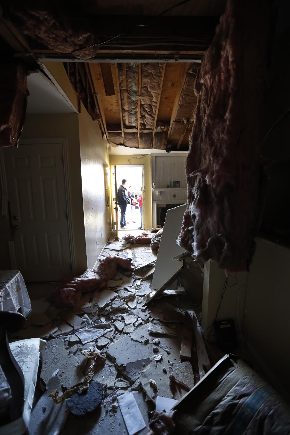 Houston Fire Chief Samuel Peña talks with Hortensia Lima, whose home was seriously damaged and deemed uninhabitable on Stanford Court in Houston, Sunday, Jan. 26, 2020, after the Friday morning explosion at the Watson Grinding Manufacturing plant. (Karen Warren/Houston Chronicle via AP)