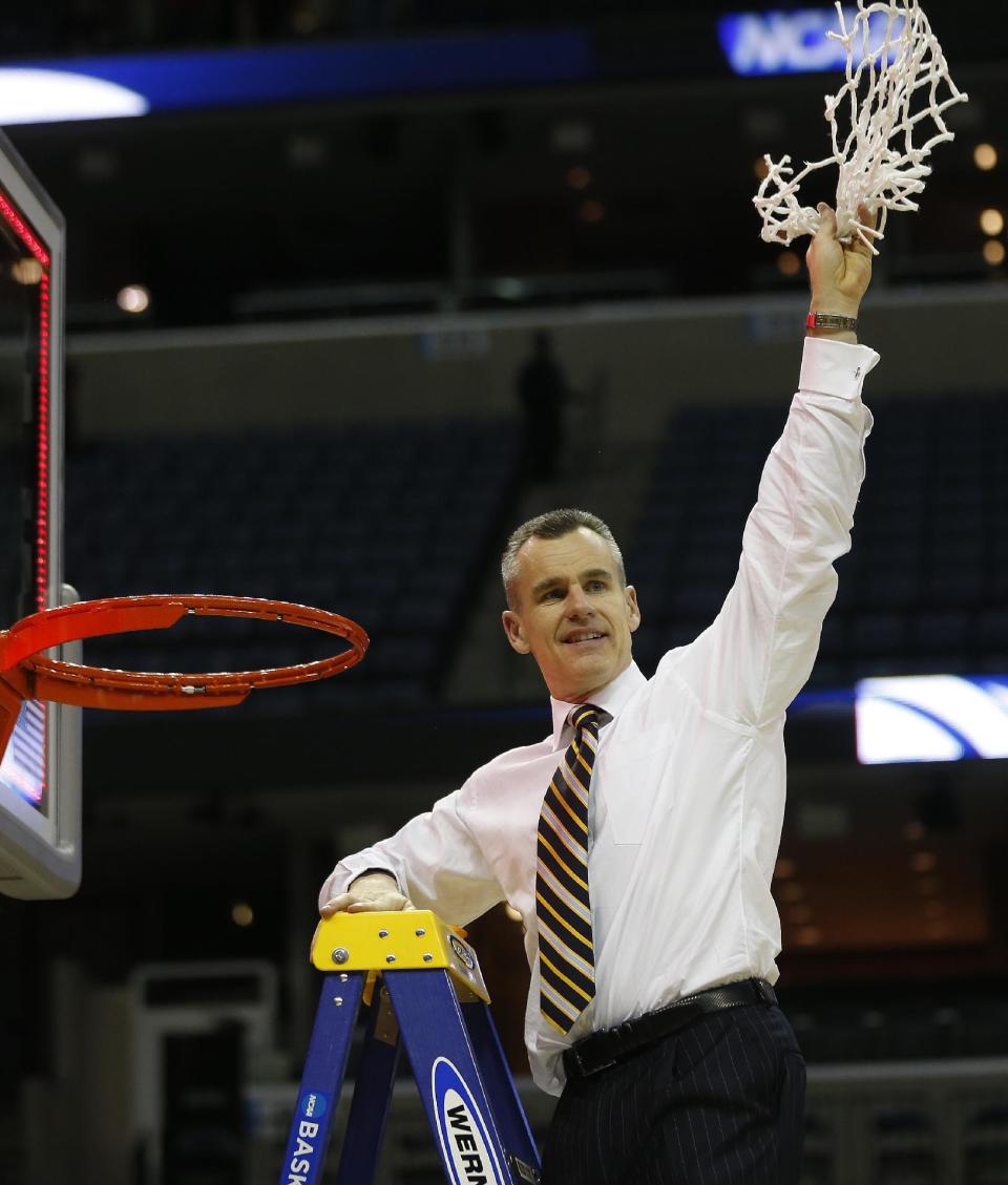 Florida head coach Billy Donovan holds the net after the second half in a regional final game against Dayton at the NCAA college basketball tournament, Saturday, March 29, 2014, in Memphis, Tenn. Florida won 62-52. (AP Photo/John Bazemore)