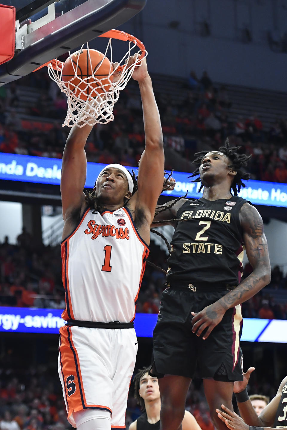 Syracuse forward Maliq Brown, left, dunks in front of Florida State forward Jamir Watkins during the second half of an NCAA college basketball game in Syracuse, N.Y., Tuesday, Jan. 23, 2024. (AP Photo/Adrian Kraus)