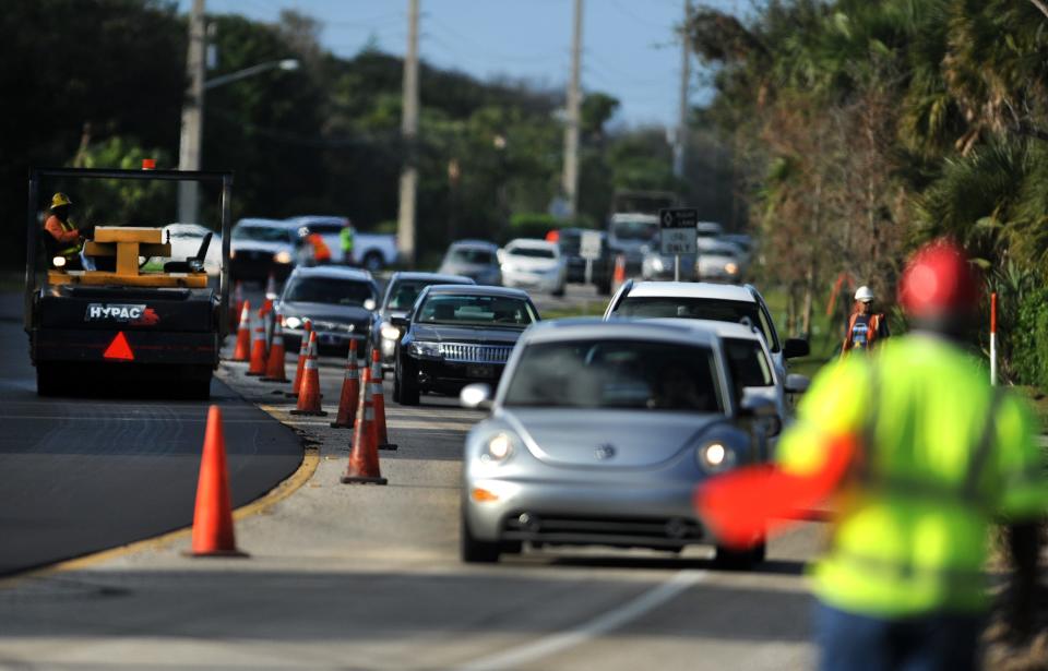 A flagman stands by as southbound traffic weaves through a series of curves along State Road A1A near White Heron Lane, about a mile north of St. Edwards School in Vero Beach, on Tuesday Dec. 13, 2011. There were long backups while traffic was funneled through one lane, alternating the north and southbound traffic, as construction crews from Ranger Construction, of Fort Pierce, re-paved several miles of the barrier island roadway in south Indian River County. 

Ranger Construction, cq 
PHOTOGRAPHED: TUESDAY DECEMBER 13, 2011